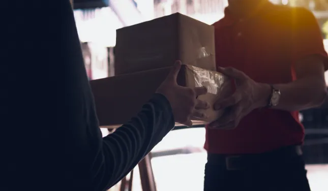 Courier handing a parcel to a customer